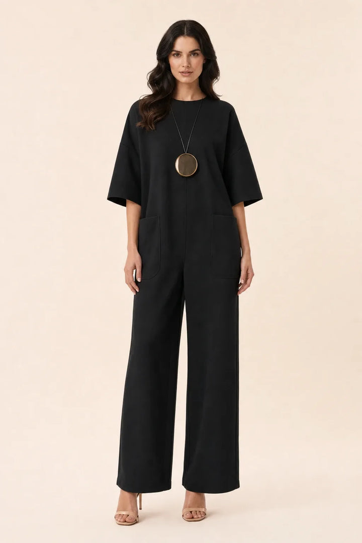 Black wide-leg jumpsuit on model in contrapposto stance, front view