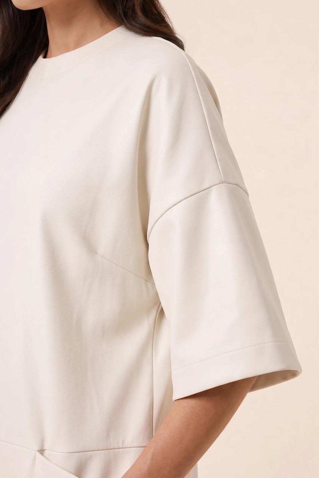 Close-up detail of white wide-leg jumpsuit fabric and construction