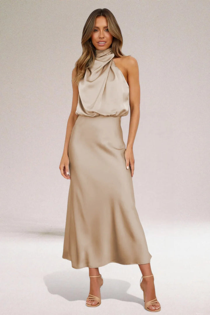 Model wearing a beige draped halter midi dress