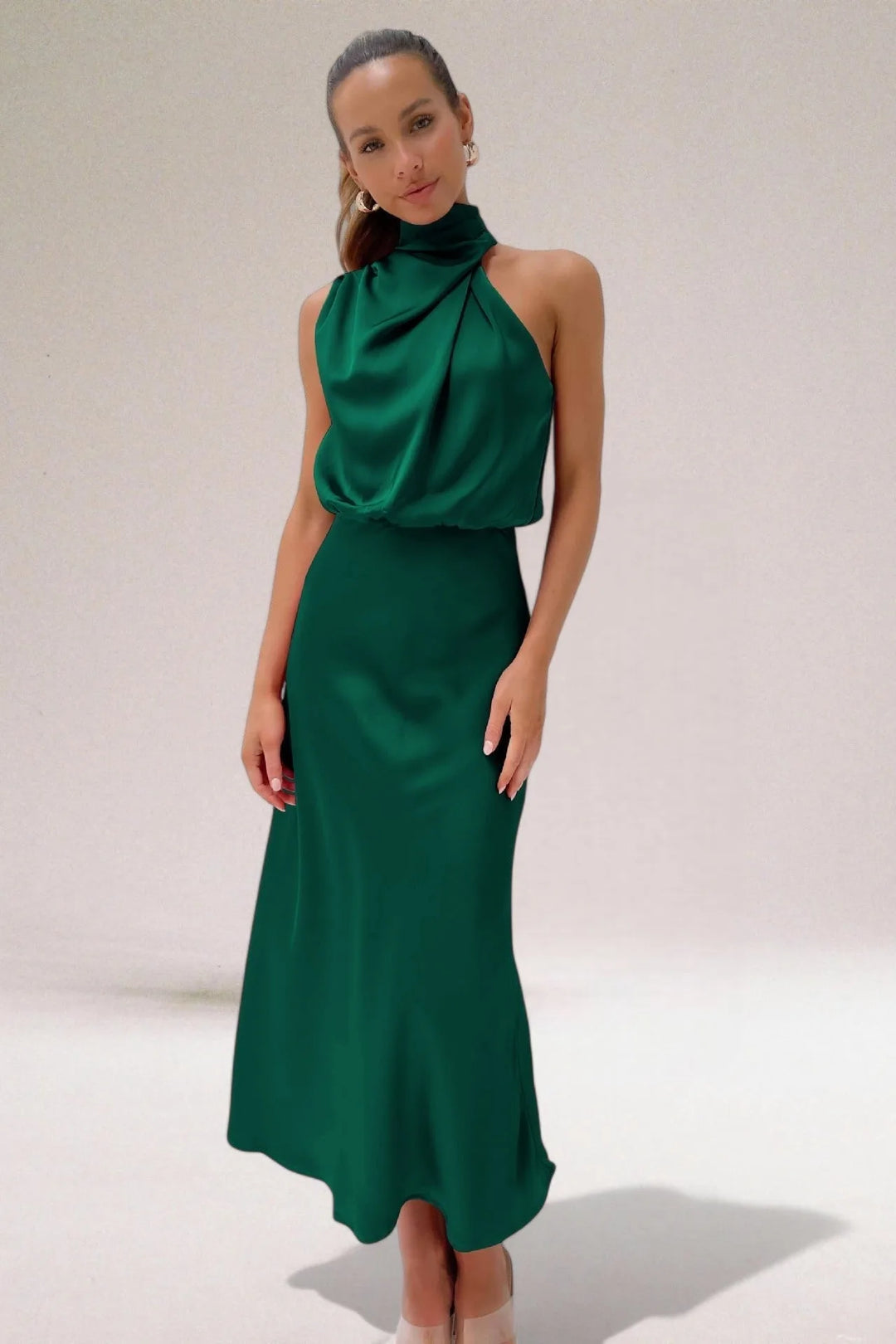 Model wearing a green draped halter midi dress