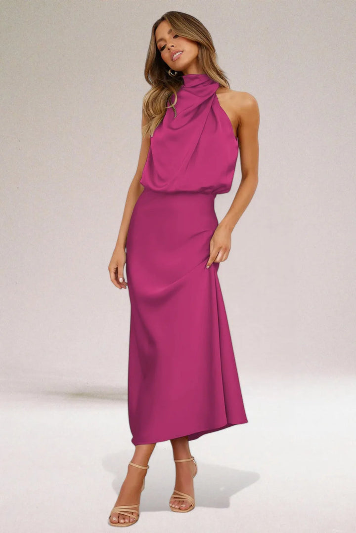 Model wearing a magenta draped halter midi dress