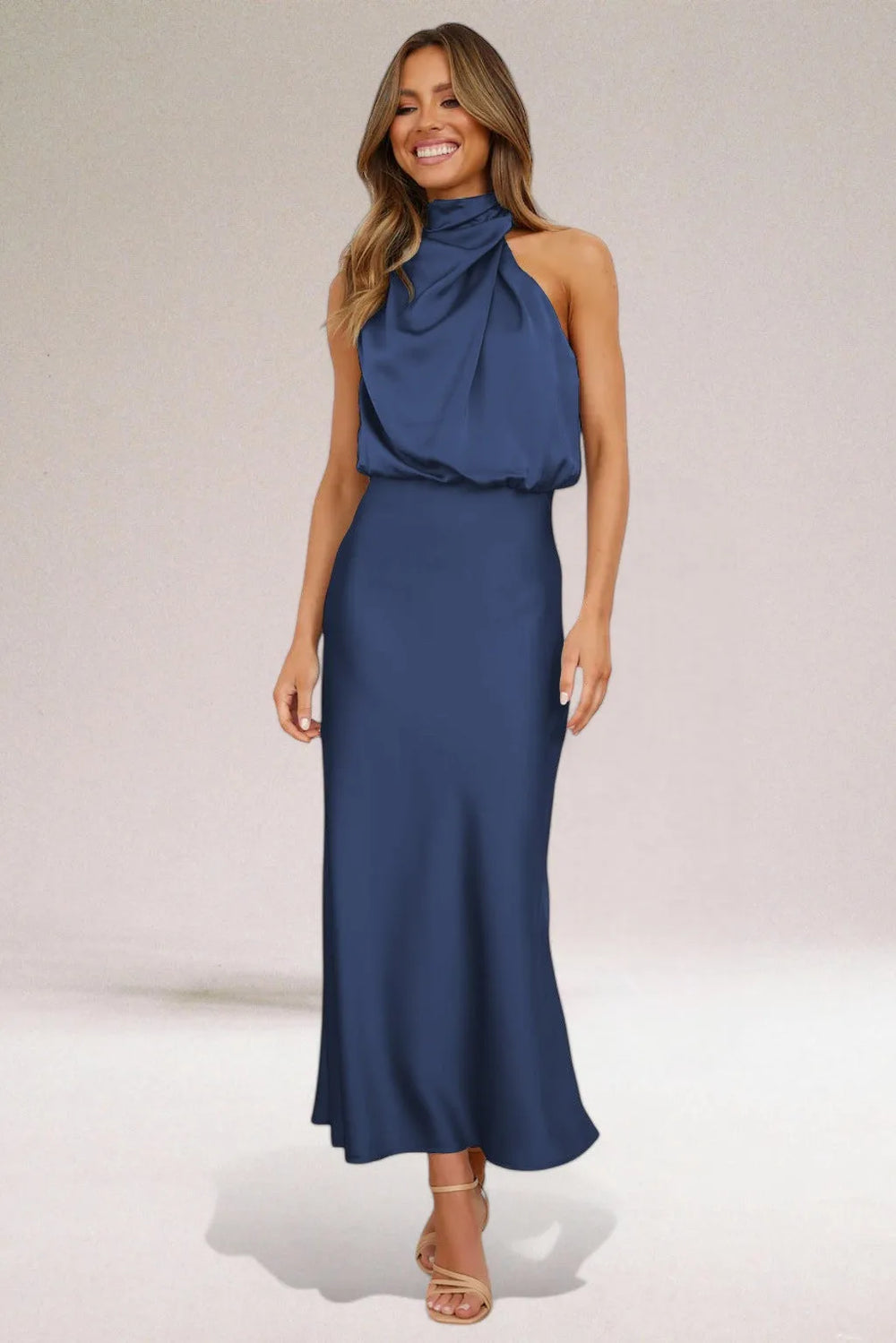 Close-up detail of a navy blue draped halter midi dress on a model