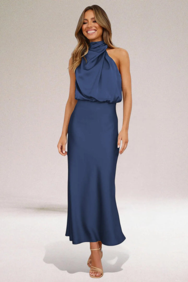 Close-up detail of a navy blue draped halter midi dress on a model