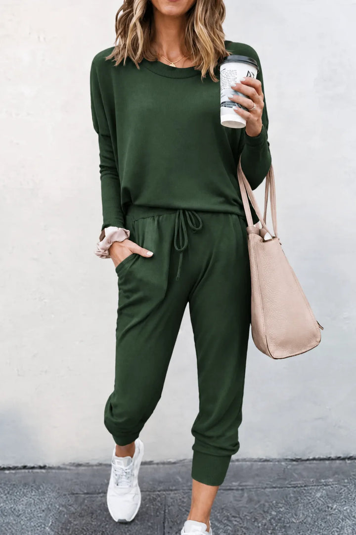 Green off-shoulder sweatshirt and jogger set on a model in a three-quarter turn pose
