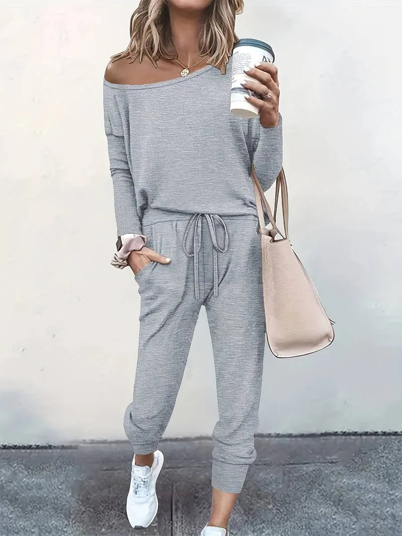 Grey off-shoulder sweatshirt and jogger set worn by a model facing forward