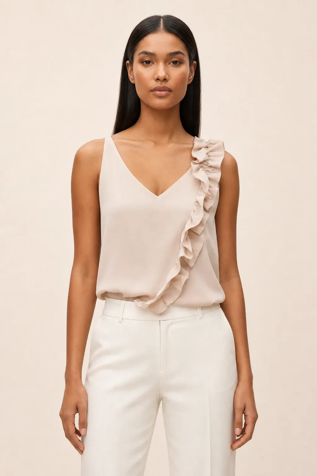 Beige asymmetric ruffle cami on model in contrapposto stance