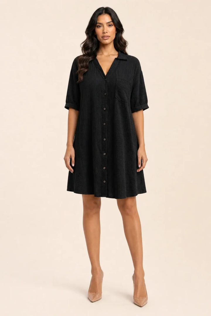 Black gauze shirt dress on model in contrapposto stance, relaxed collar and button-front silhouette