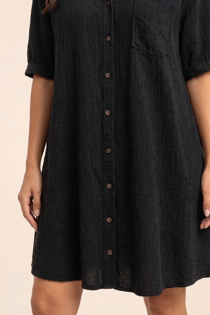 Close-up detail of black gauze shirt dress fabric, buttons, and collar construction