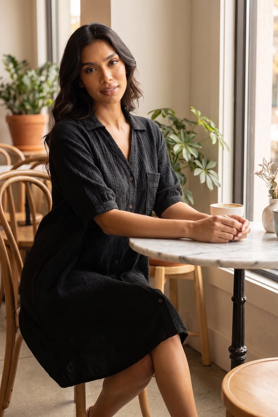 Model wearing black gauze shirt dress in a second lifestyle setting