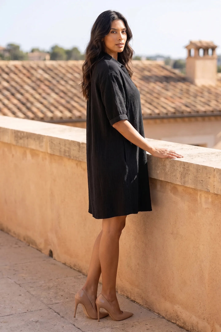 Model wearing black gauze shirt dress in a natural lifestyle setting
