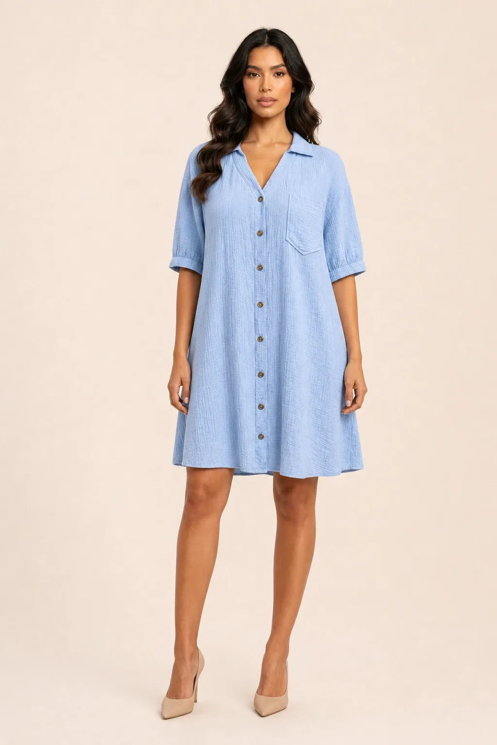 Sky blue gauze shirt dress on model in contrapposto stance, relaxed collar and button-front silhouette