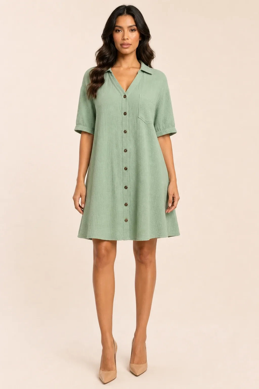Turquoise gauze shirt dress on model in contrapposto stance, relaxed collar and button-front silhouette