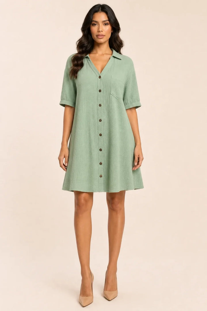 Turquoise gauze shirt dress on model in contrapposto stance, relaxed collar and button-front silhouette