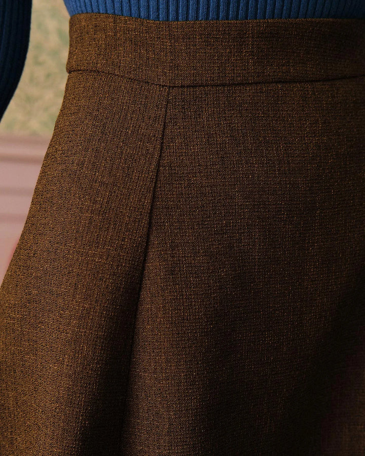 Brown pleated A-line midi skirt on model, three-quarter turn