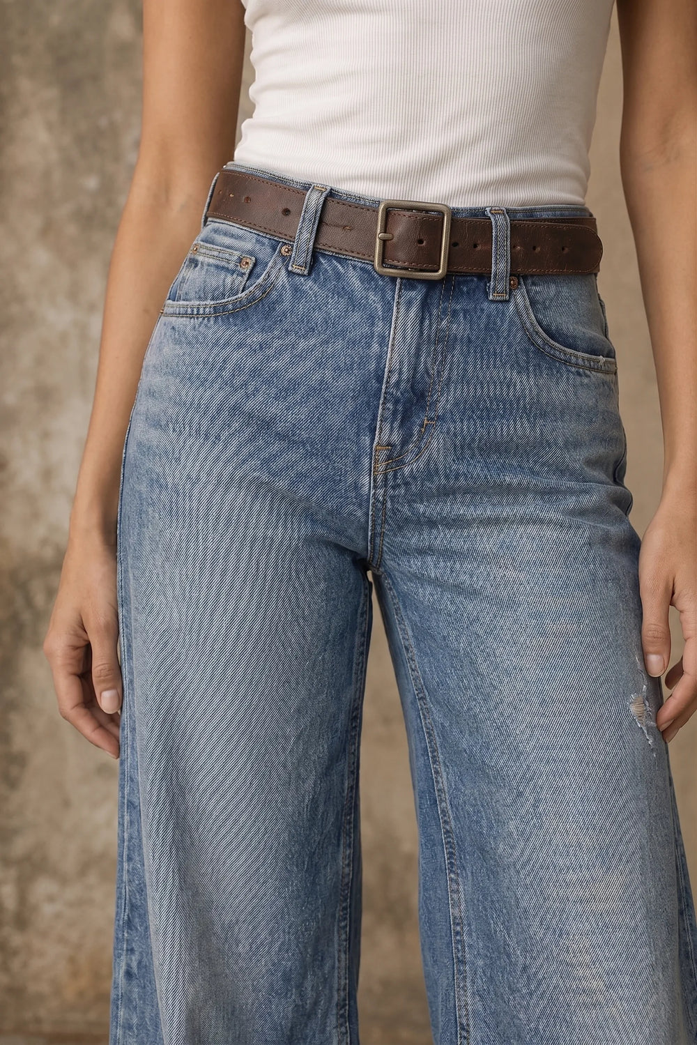 Close-up detail of light blue wide-leg flare denim fabric and fit