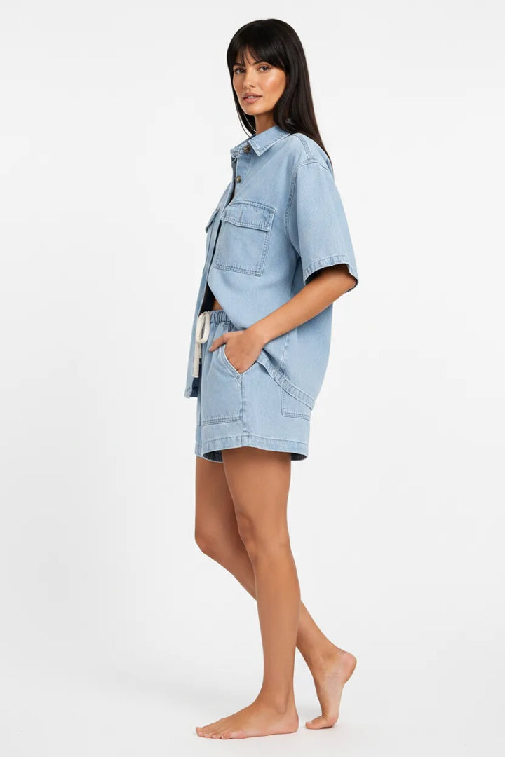 Light blue denim shirt set on model in three-quarter turn