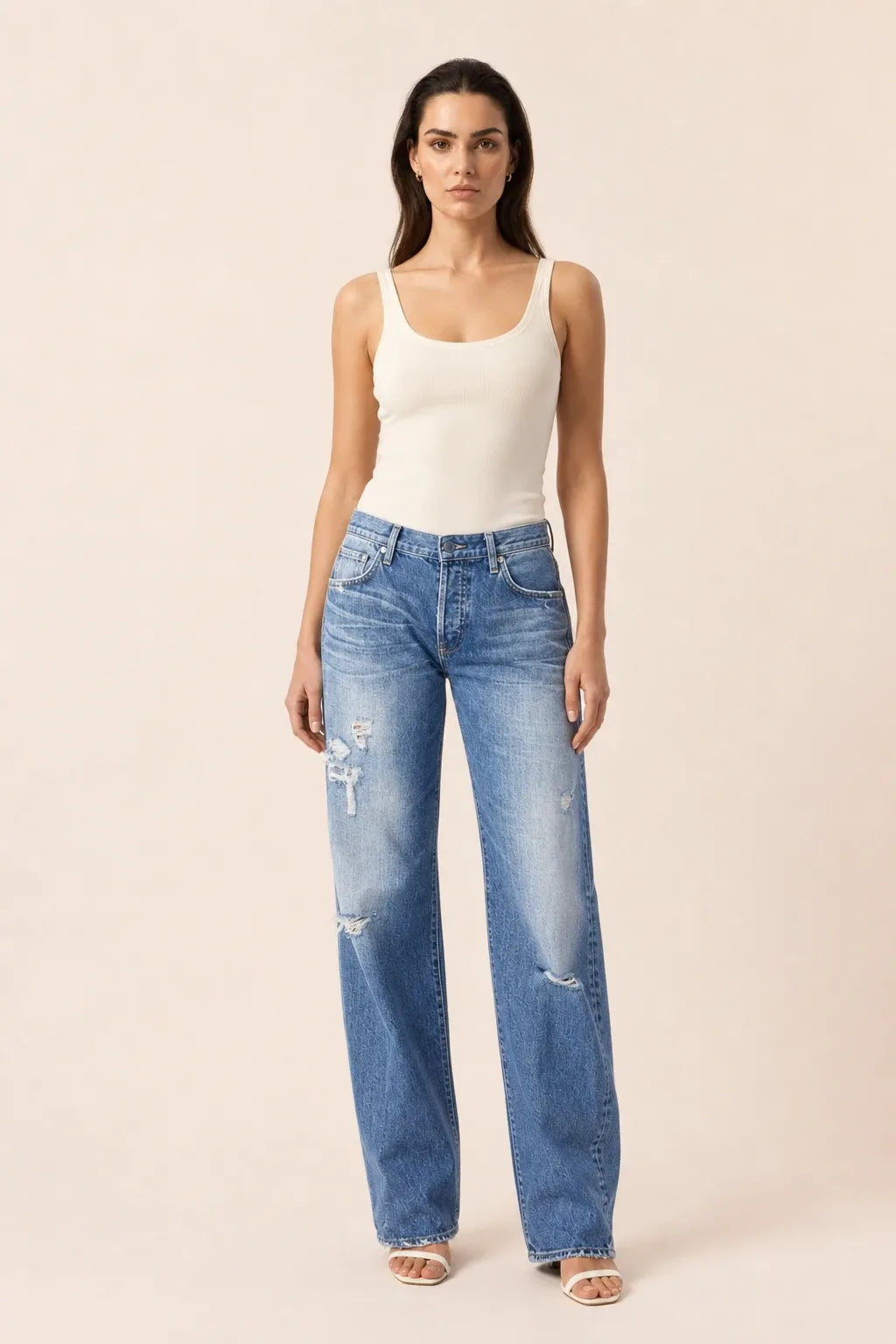 Blue distressed wide leg jeans on a model in a contrapposto stance