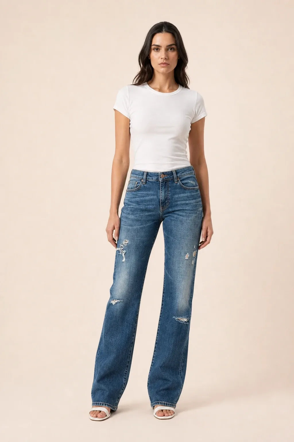 Dark blue distressed wide leg jeans on a model in a contrapposto stance