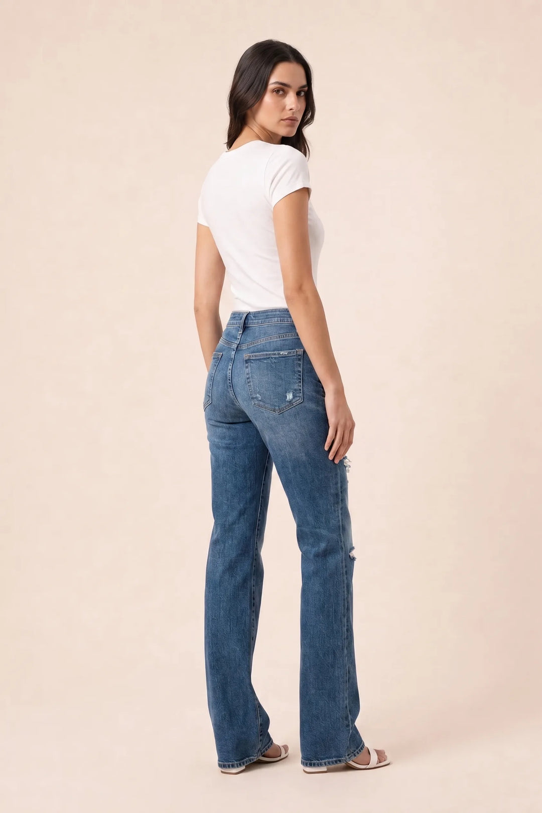Dark blue distressed wide leg jeans on a model in a three-quarter turn