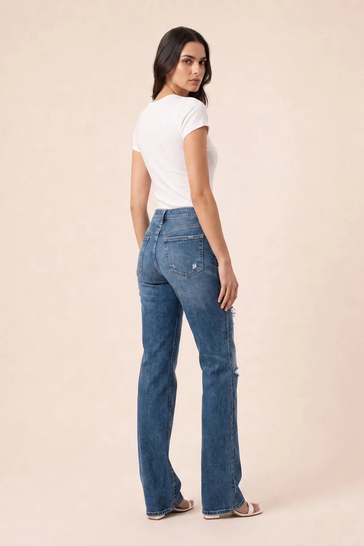 Dark blue distressed wide leg jeans on a model in a three-quarter turn