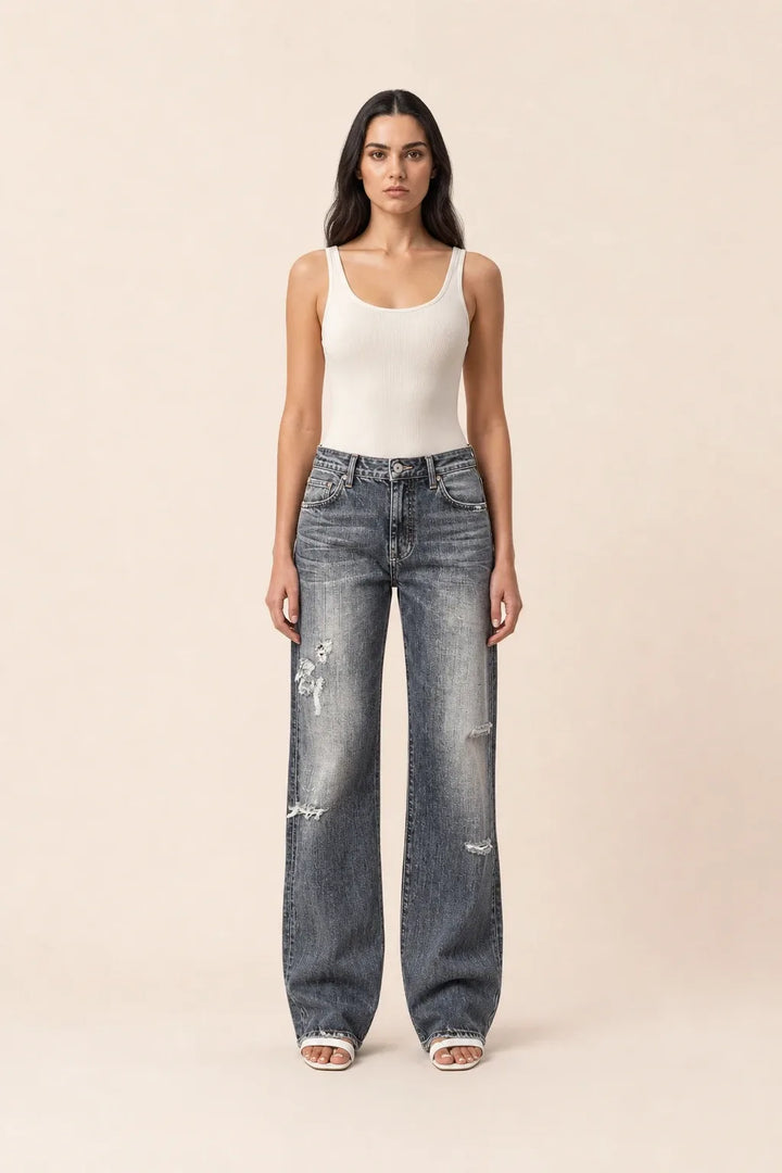 Gray distressed wide leg jeans on a model in a contrapposto stance