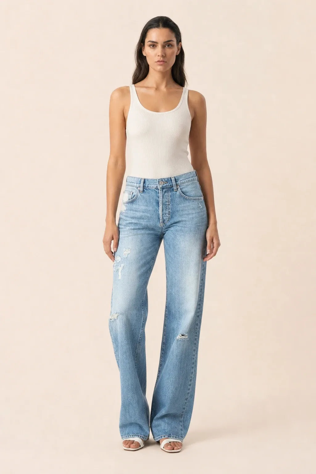 Light blue distressed wide leg jeans on a model in a contrapposto stance