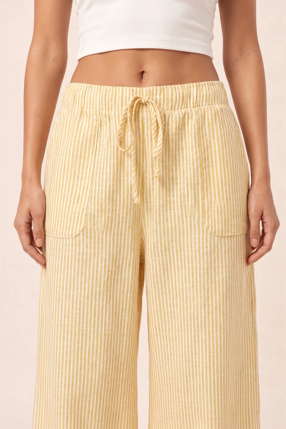 Close-up detail of yellow striped wide-leg pants fabric and fit