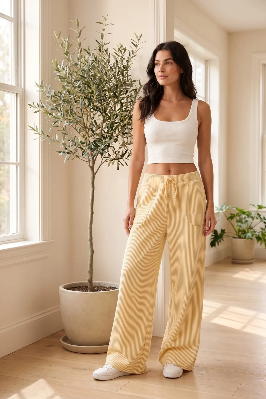 Model wearing yellow striped wide-leg pants in lifestyle setting