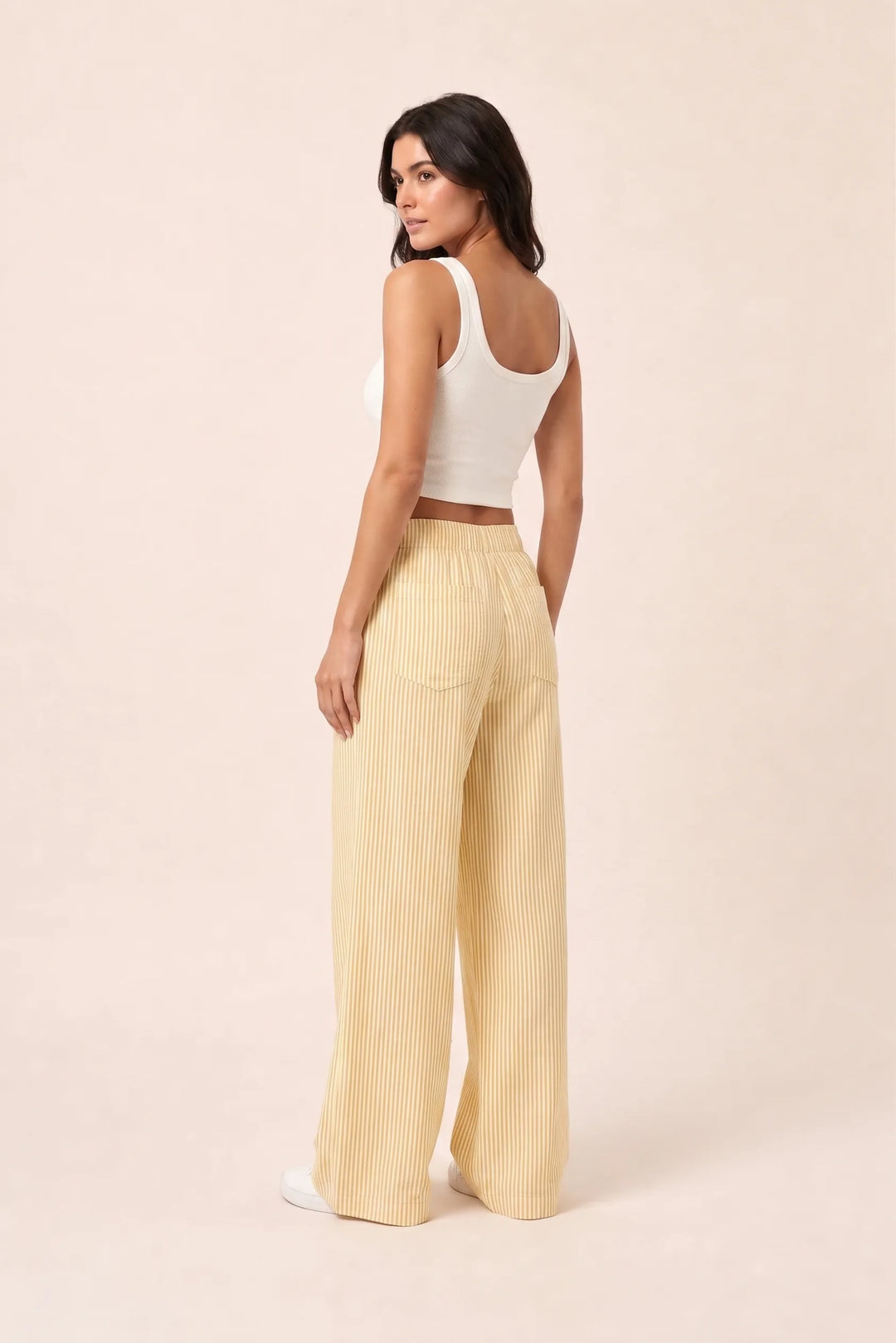 Yellow striped wide-leg pants on model in three-quarter turn pose