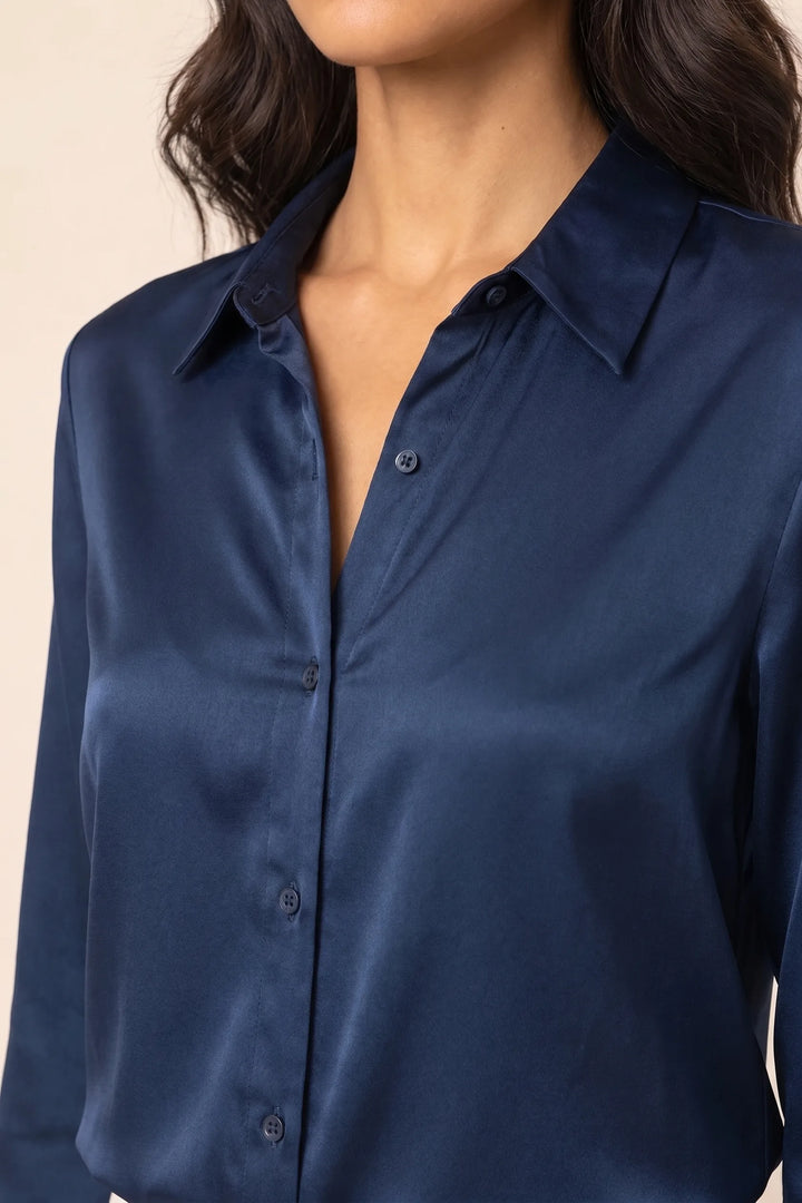 Close-up detail of navy blue satin button-front blouse