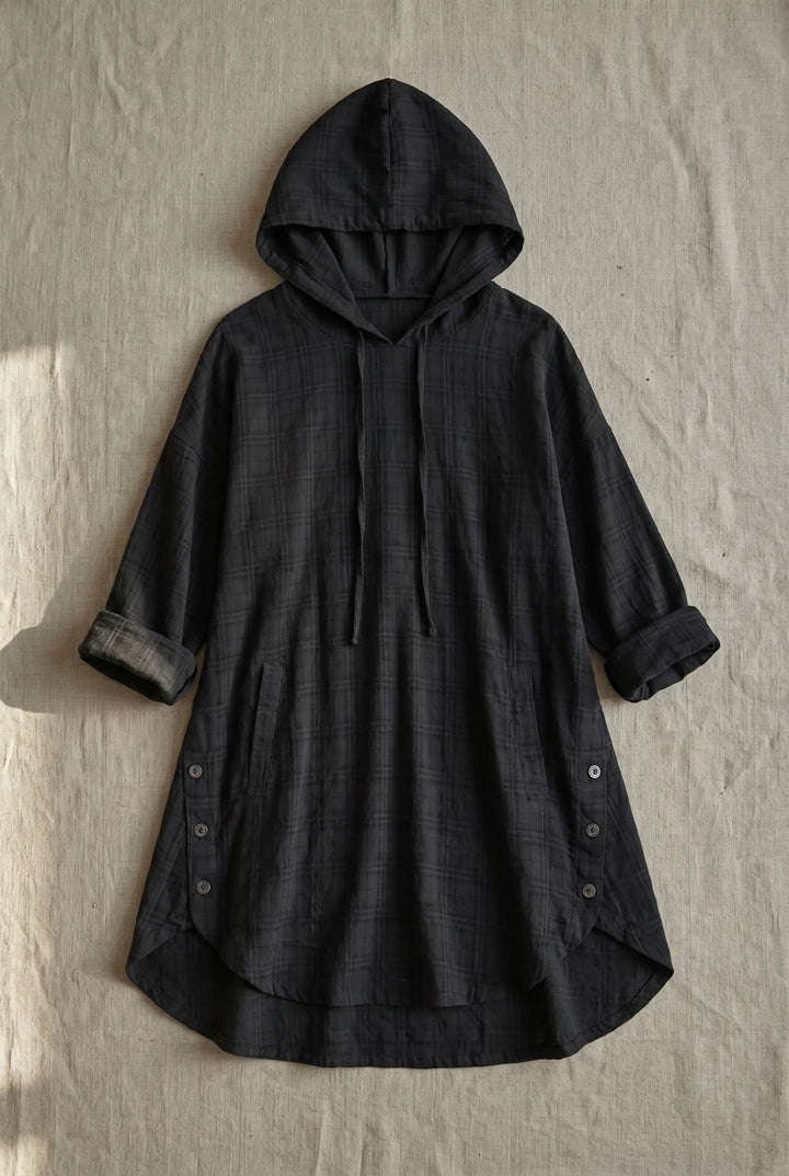 Black hooded tunic dress laid flat, showing full-length silhouette with drawstring hood and relaxed fit