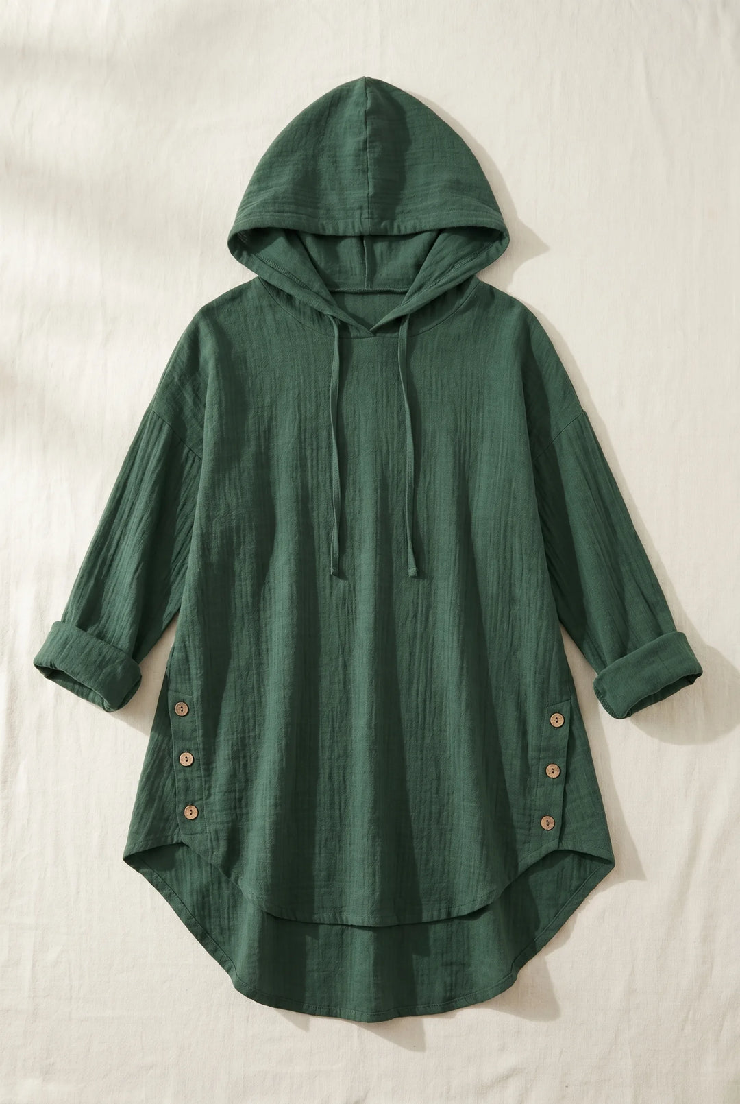 Green hooded tunic dress laid flat, showing full-length silhouette with drawstring hood and relaxed fit