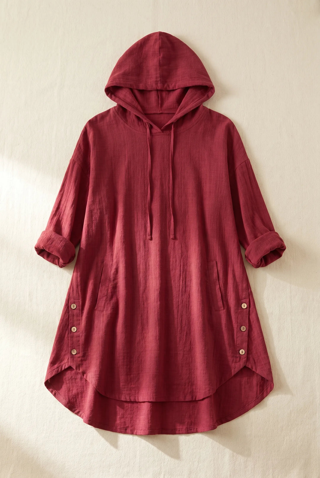 Wine red hooded tunic dress laid flat, displaying full-length relaxed silhouette with drawstring hood