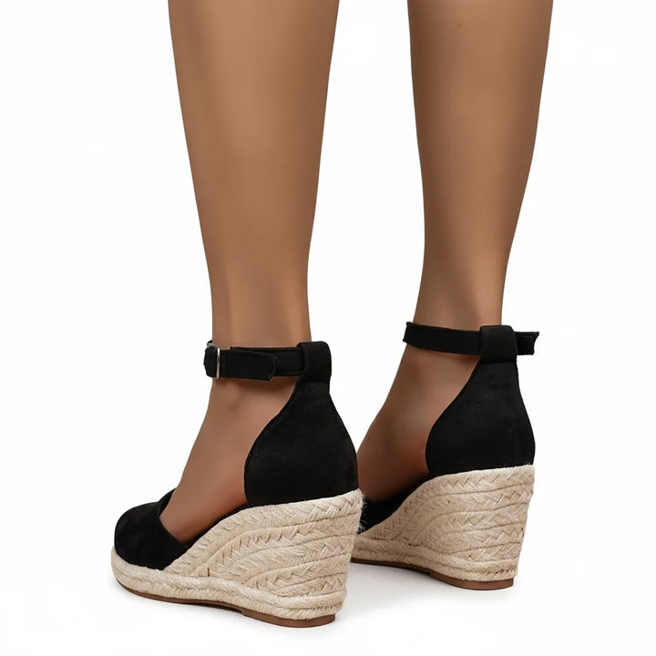 Black espadrille wedge sandal, rear view of heel and ankle strap closure