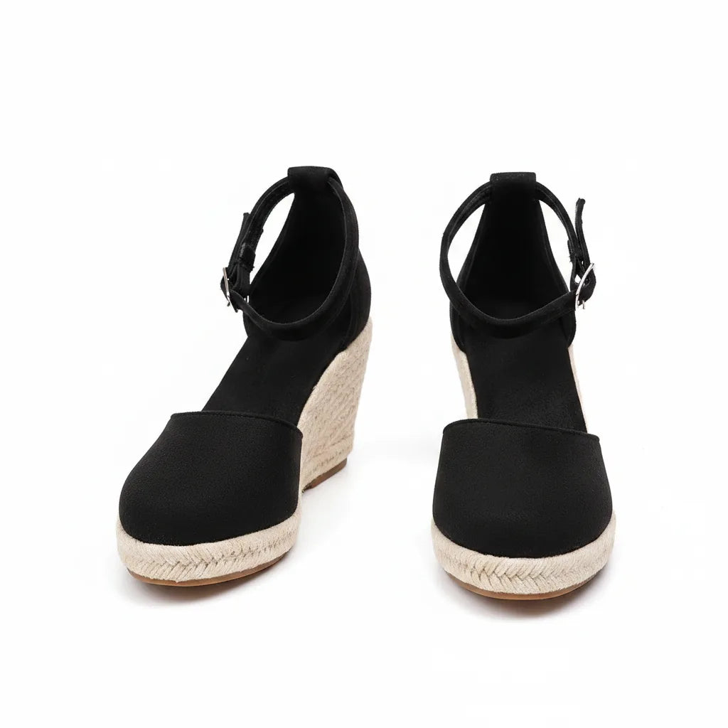 Black espadrille wedge sandal, three-quarter view displaying straps and jute sole