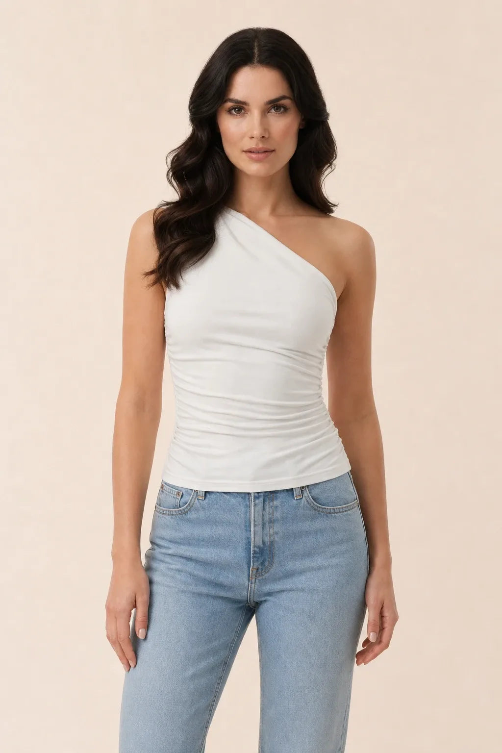 White one-shoulder ruched top on model in contrapposto stance