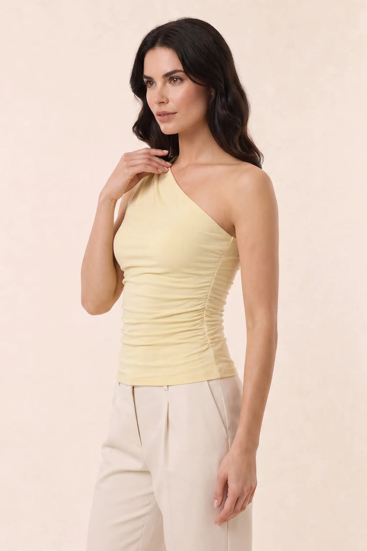 Yellow one-shoulder ruched top on model at three-quarter turn