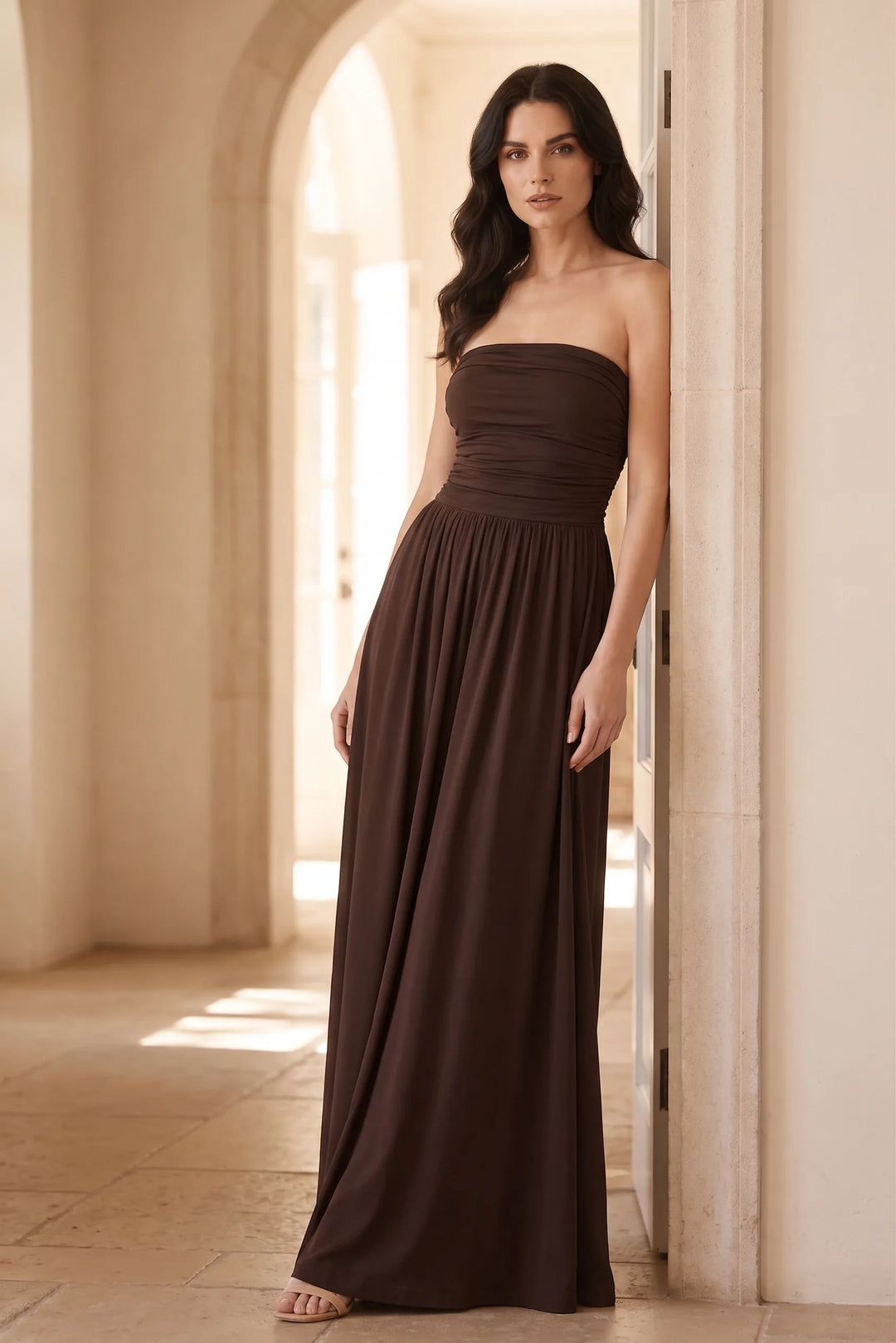 Woman in brown strapless ruched maxi dress in an outdoor lifestyle setting