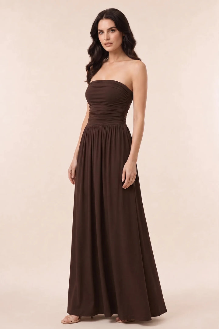 Woman in brown strapless ruched maxi dress in three-quarter turn