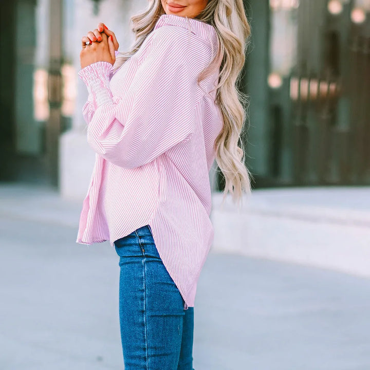 Model wearing a blue balloon sleeve blouse with smocked cuffs, styled view