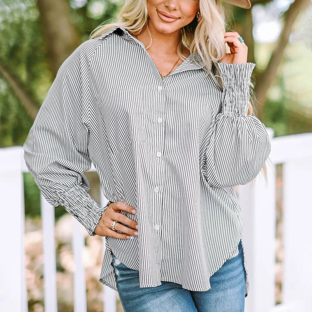 Model at three-quarter turn wearing a gray balloon sleeve blouse with smocked cuffs