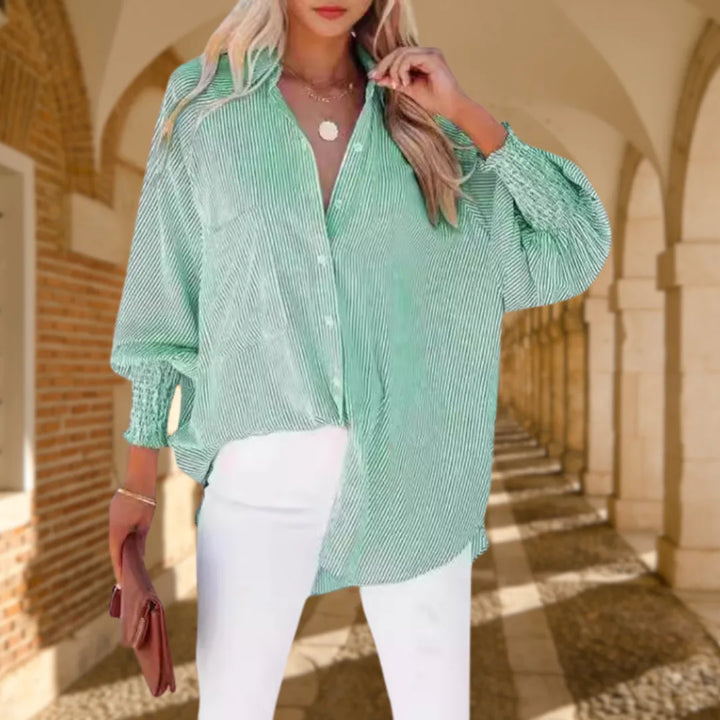 Model wearing a green balloon sleeve blouse with smocked cuffs