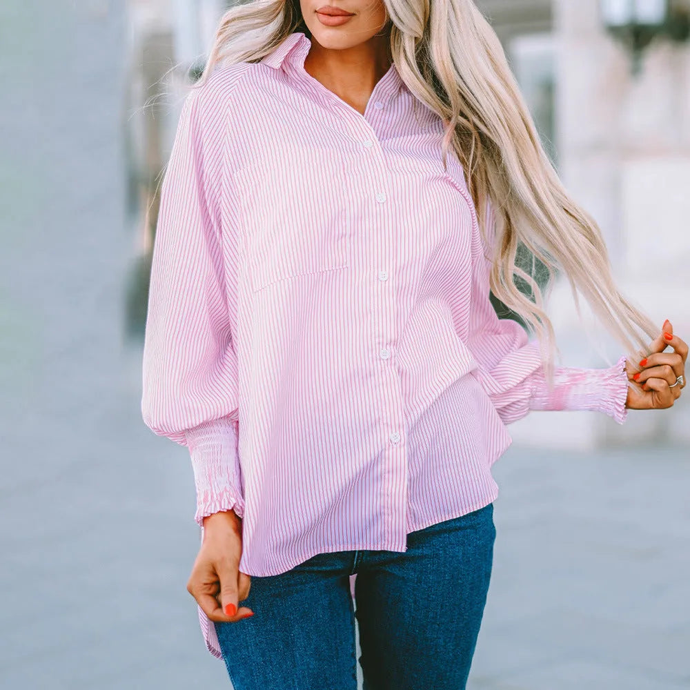 Model in side profile wearing a pink balloon sleeve blouse with smocked cuffs