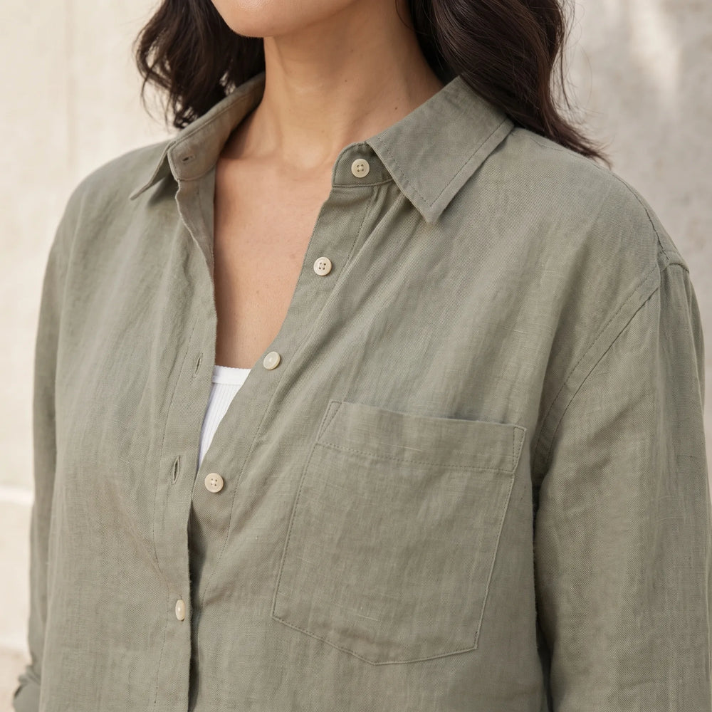 Close-up detail of cropped dark green button-down shirt