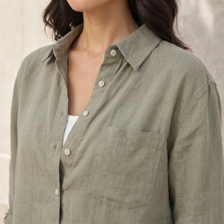 Close-up detail of cropped dark green button-down shirt