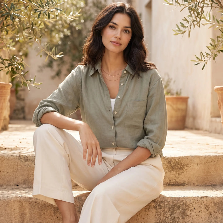 Model wearing cropped dark green button-down shirt in outdoor lifestyle setting