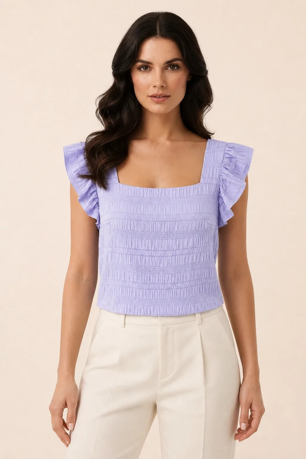 Purple smocked ruffle sleeve top on model in contrapposto stance