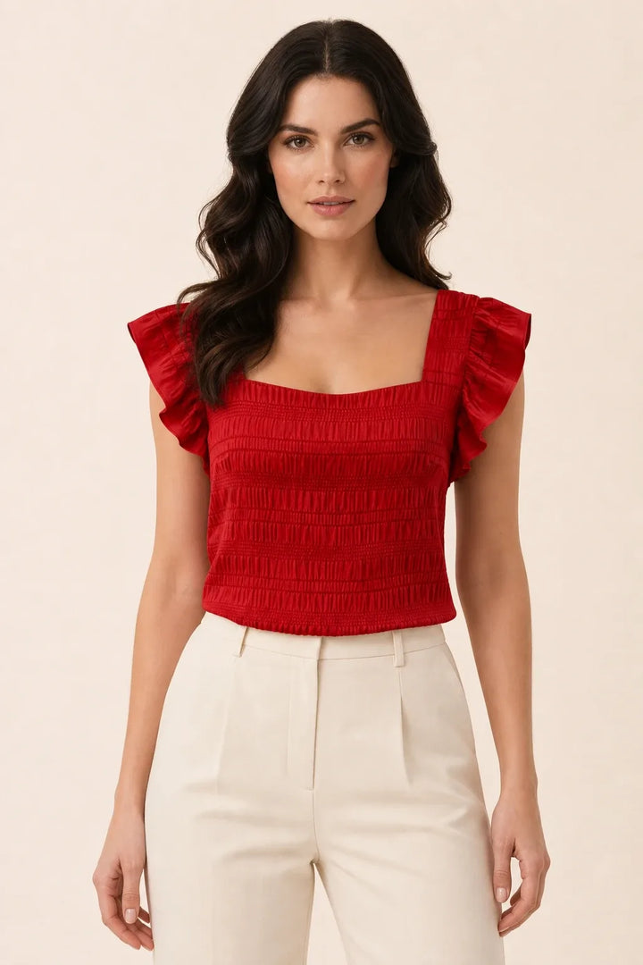 Red smocked ruffle sleeve top on model in contrapposto stance