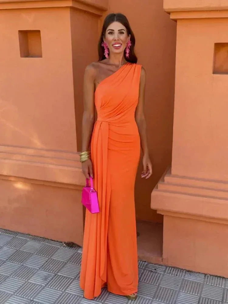 Woman facing forward in a draped orange one-shoulder maxi dress