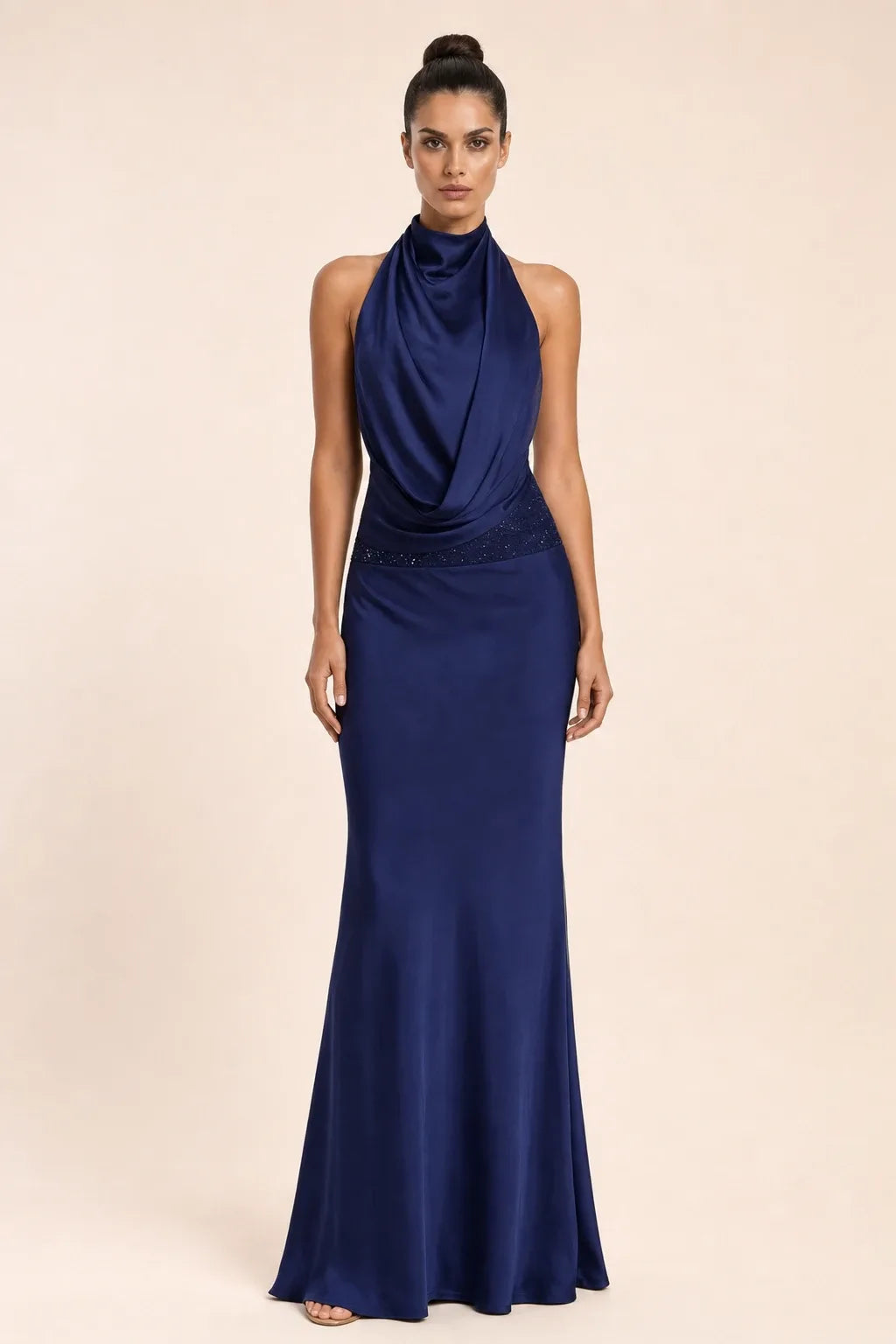 Navy blue draped open-back gown on model in contrapposto stance